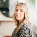 Natural light portrait of a woman in a salon, highlighting natural beauty and professional style.